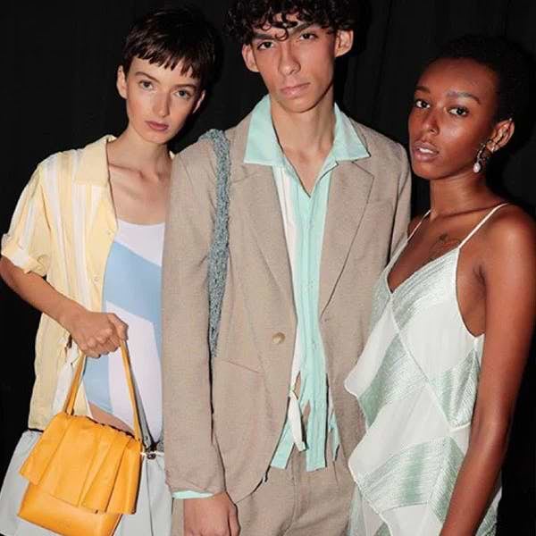 A group of three people standing next to each other