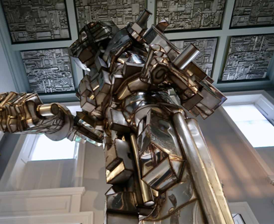 A sculpture of a man holding a sword in a room