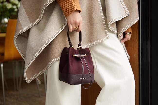 A woman is holding a brown and black purse