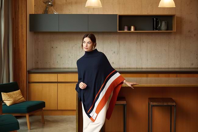 A woman standing in a kitchen holding a blanket