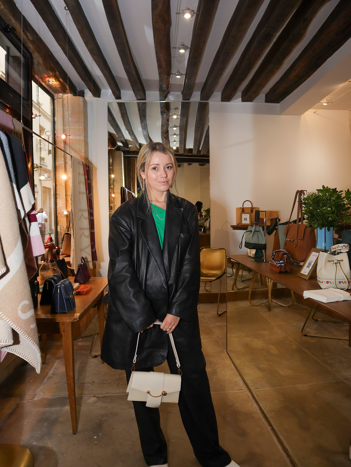A woman standing in a room holding a purse