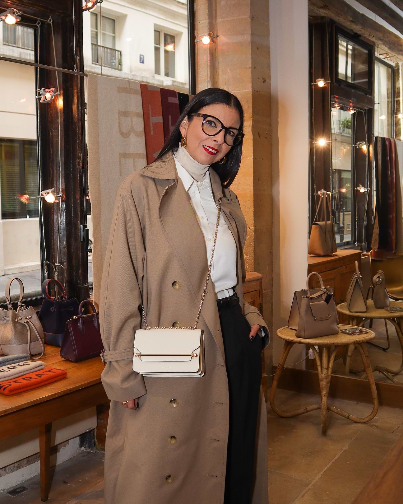 A woman wearing a trench coat and holding a purse