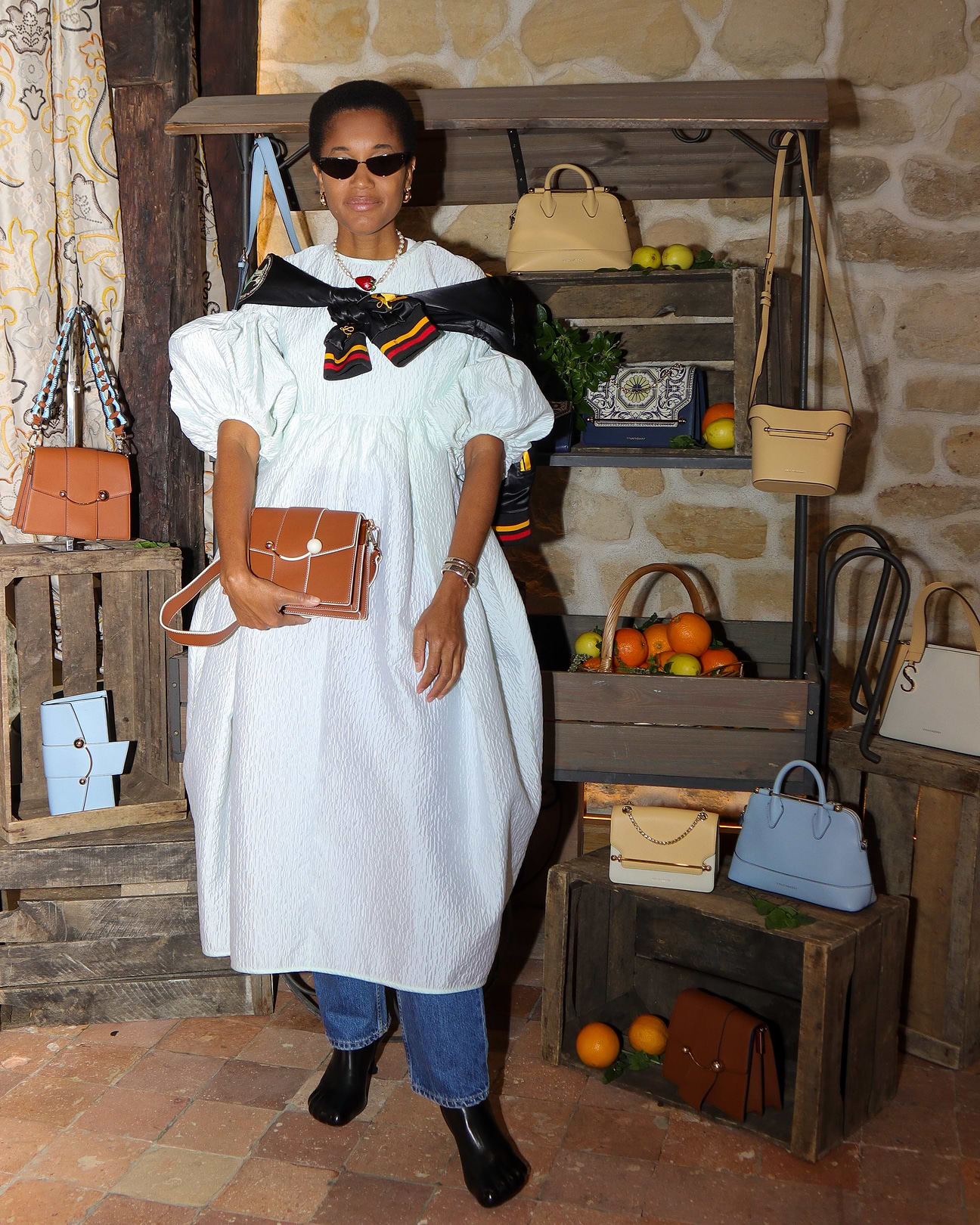 A woman standing in front of a display of purses