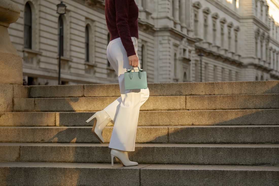 A woman walking up some steps carrying a purse