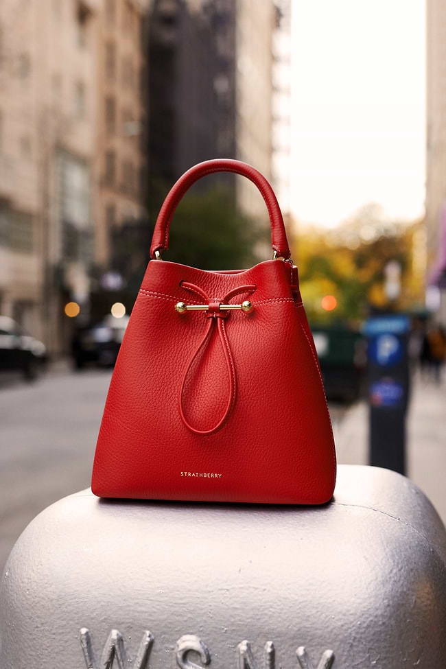 A red purse sitting on top of a metal object