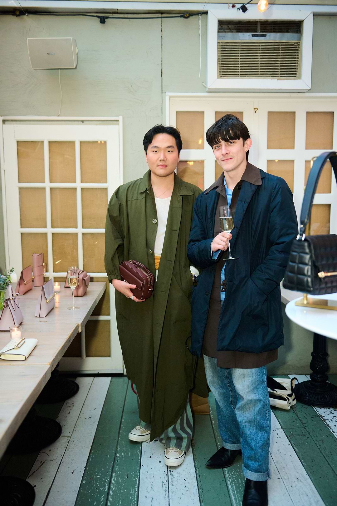 Two men standing next to each other holding wine glasses