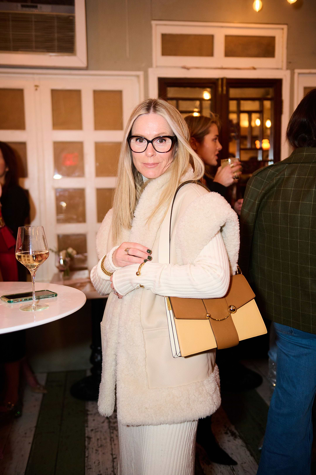 A woman standing in a room holding a purse