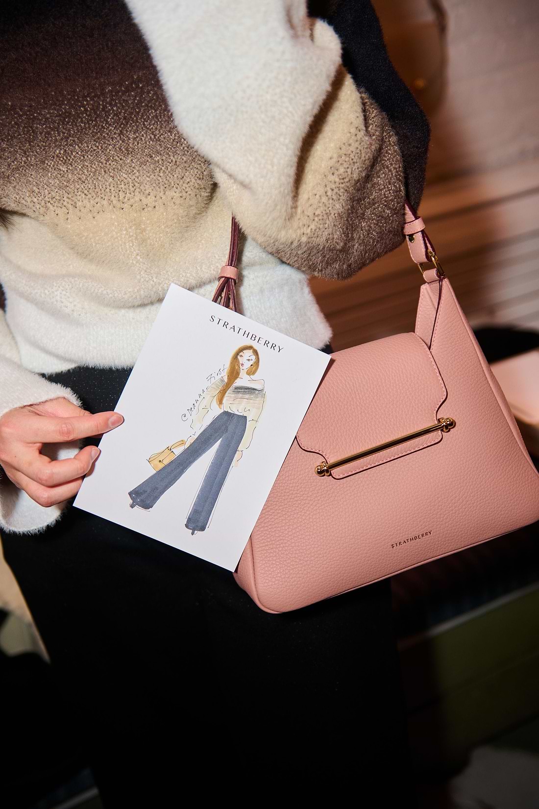 A woman holding a pink purse and a card