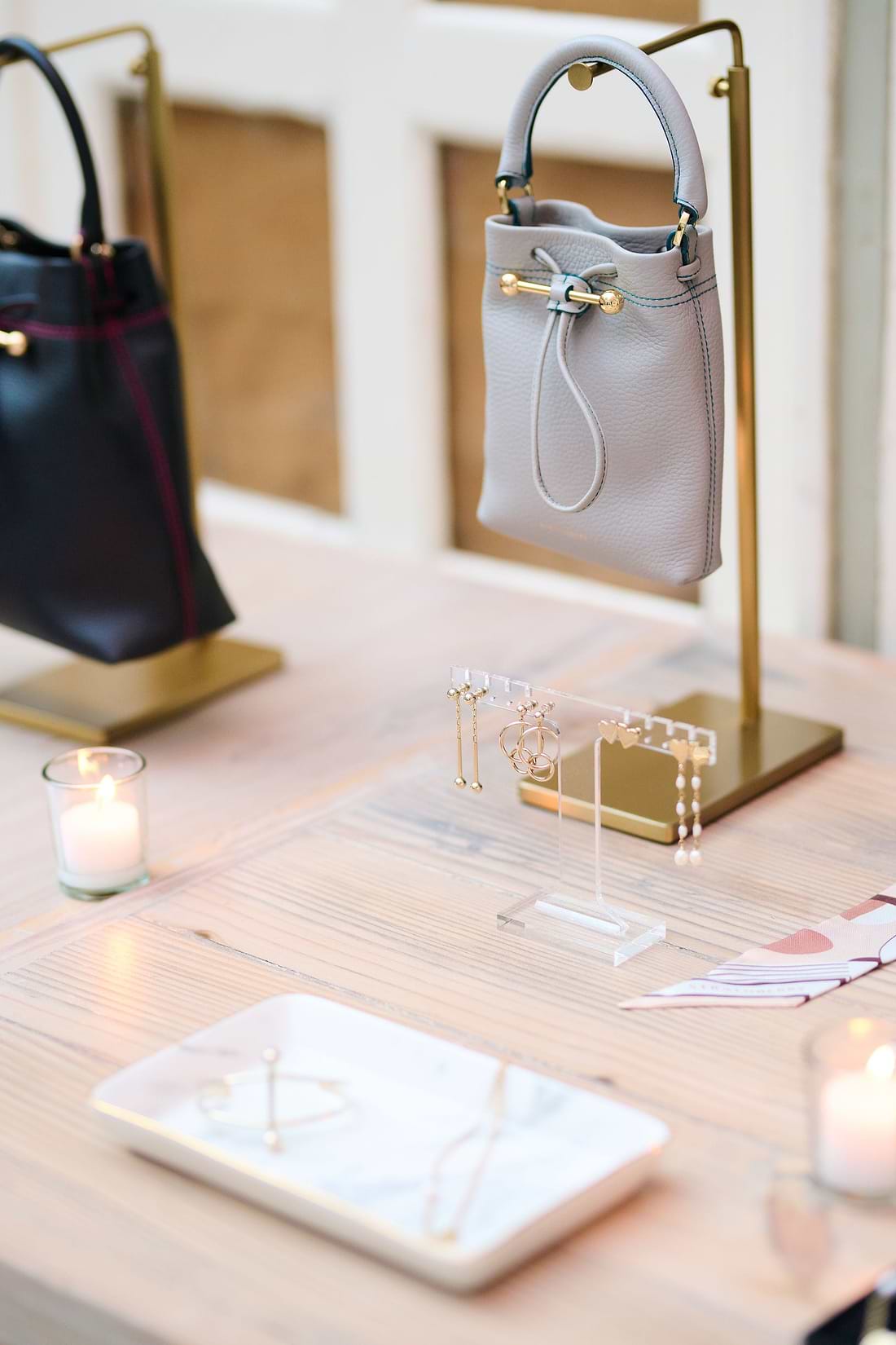 A table topped with a purse and a candle