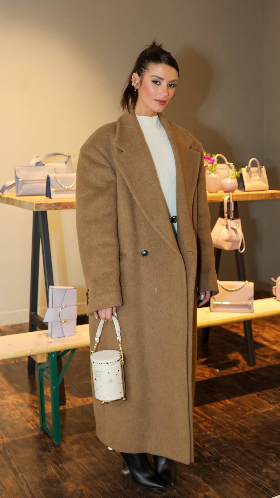 A woman standing in front of a display of handbags