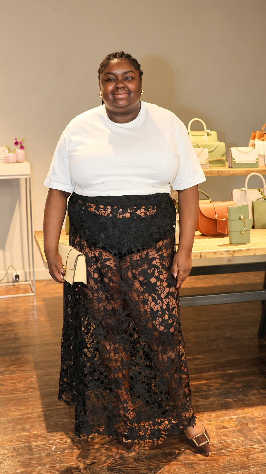 A woman standing in front of a display of purses