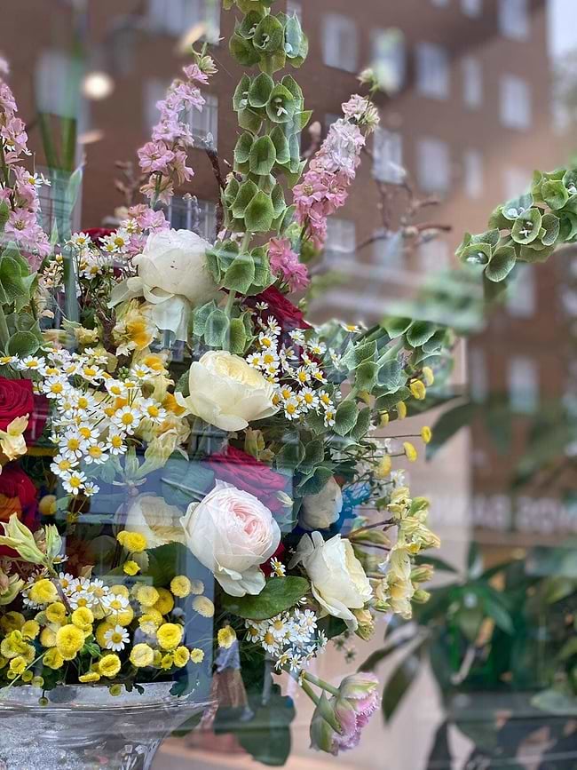 A vase filled with lots of different colored flowers