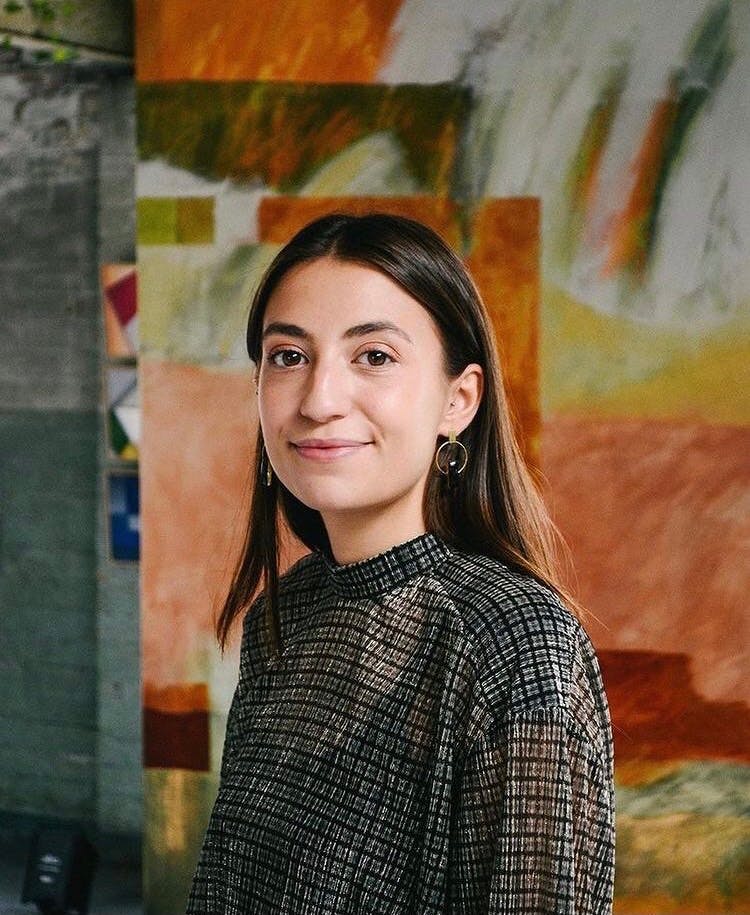 A woman standing in front of a painting