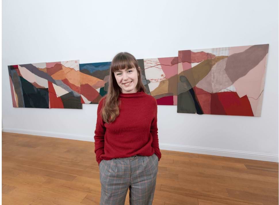 A woman standing in front of two paintings