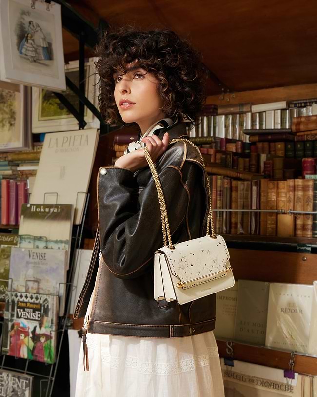 A woman in a white dress holding a white purse