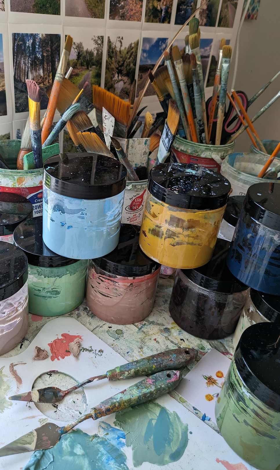 A table topped with lots of paint and brushes