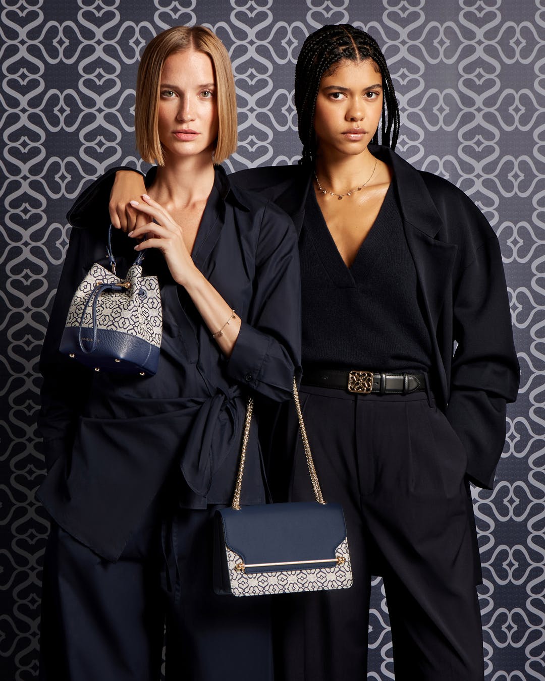 Two women standing next to each other holding purses