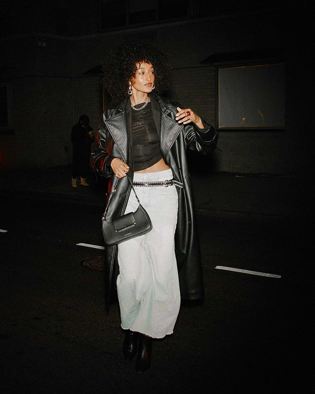 A woman walking down a street at night
