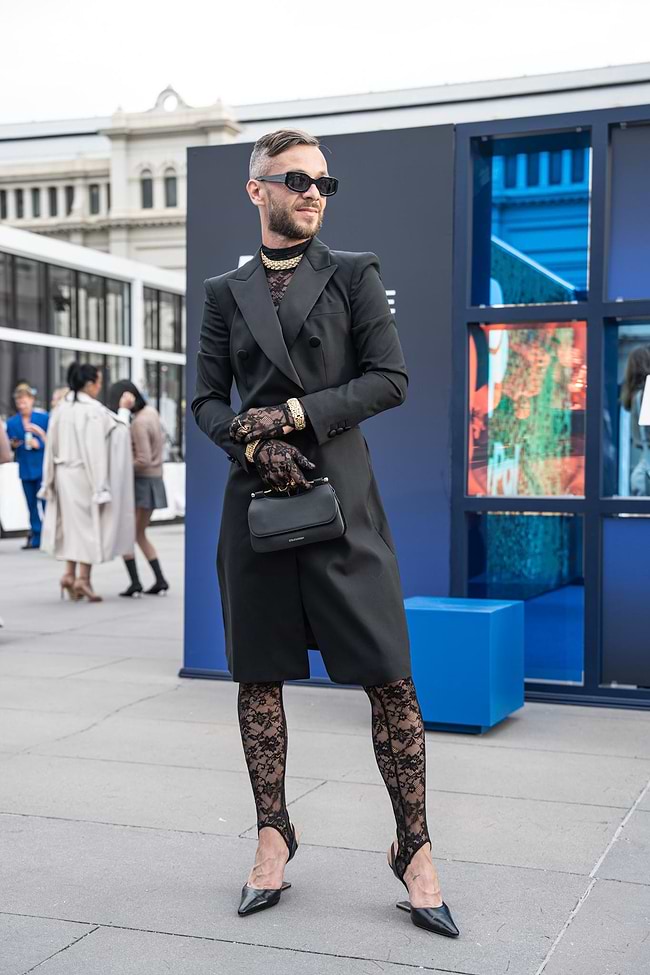 A man in a black coat and patterned tights