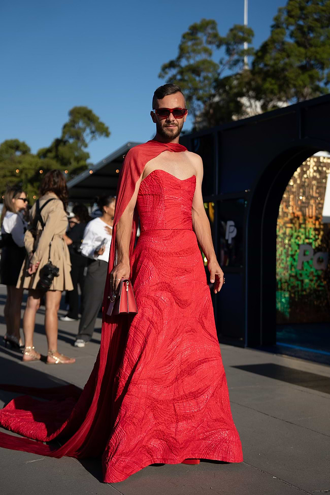 A woman in a red dress is walking down the street