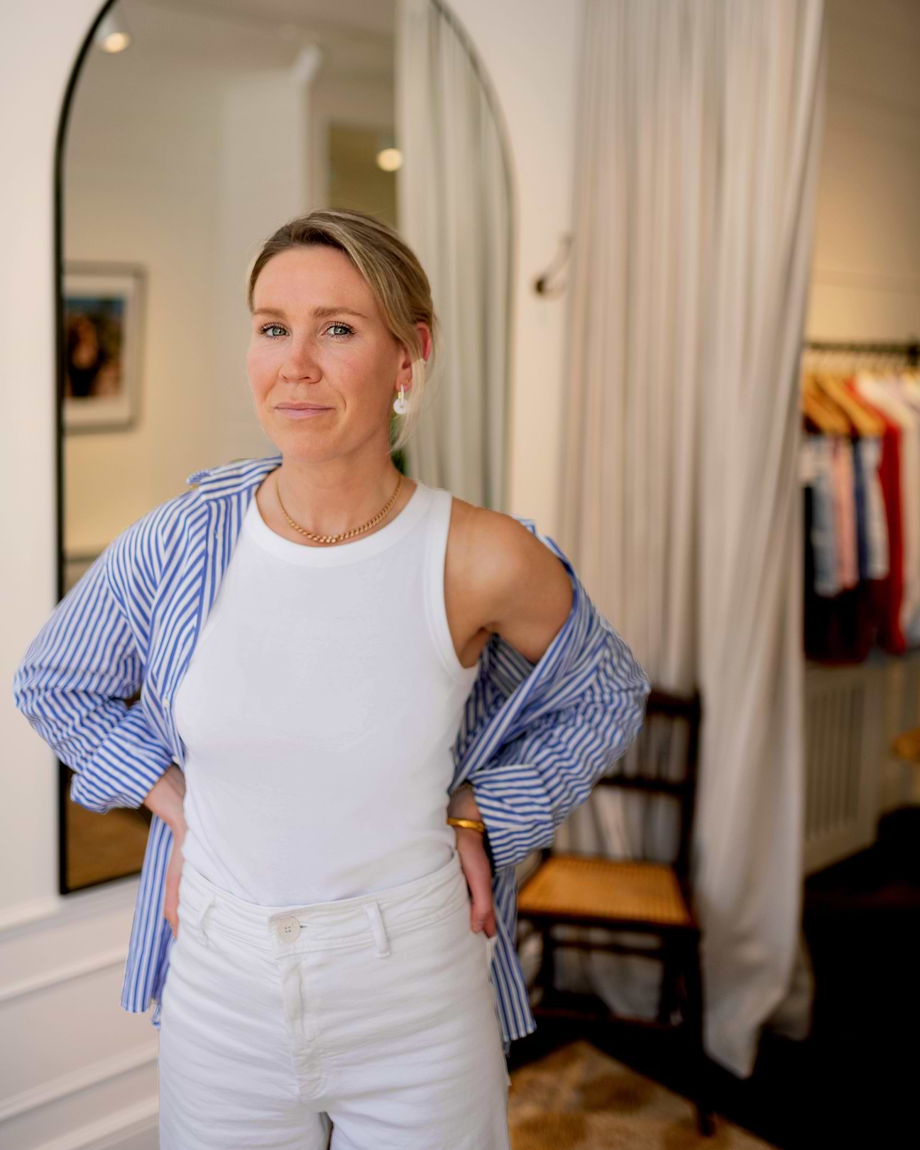 A woman standing in front of a mirror with her hands on her hips