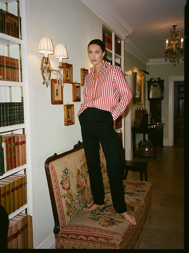 A woman standing on a couch in a room