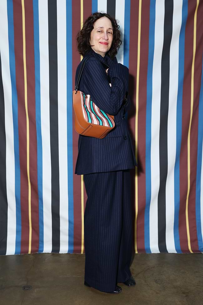 A woman standing in front of a striped wall
