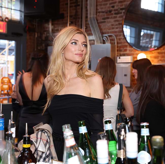 A woman standing in front of a table full of bottles