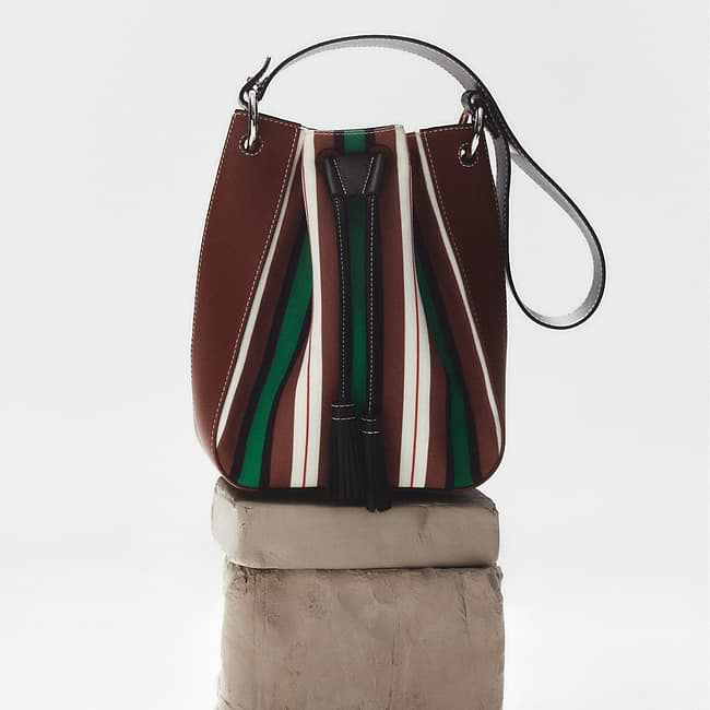 A brown and green purse sitting on top of a block