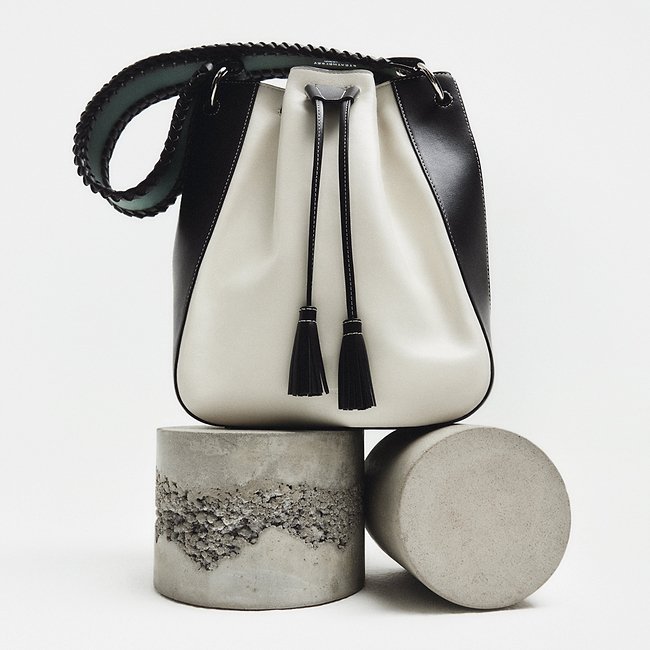 A white and black purse sitting on top of a cement block