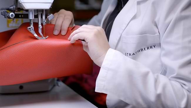 A woman is working on a red bag