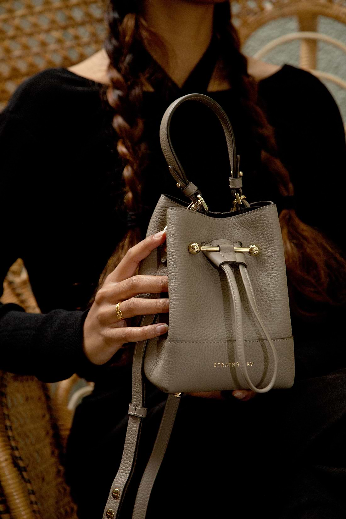 A woman holding a gray purse in her hand