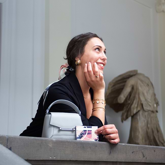 A woman sitting at a table with her hand on her face
