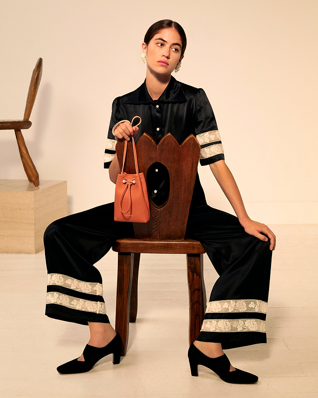 A woman sitting on a chair holding a purse
