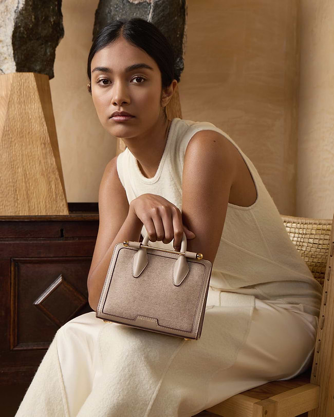 A woman sitting on a chair holding a purse
