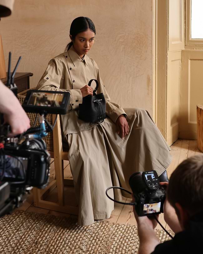 A woman sitting in a chair with a camera