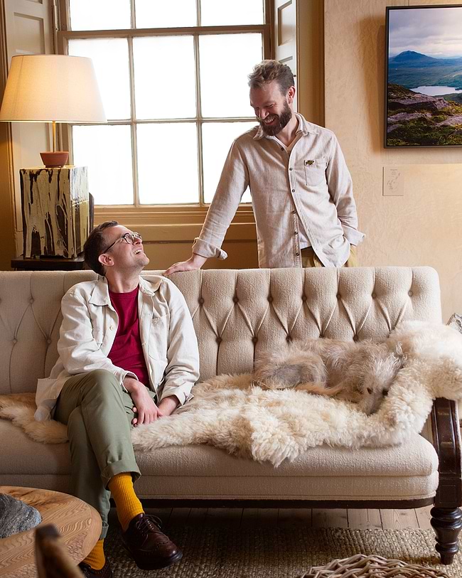 A man sitting on a couch next to a dog