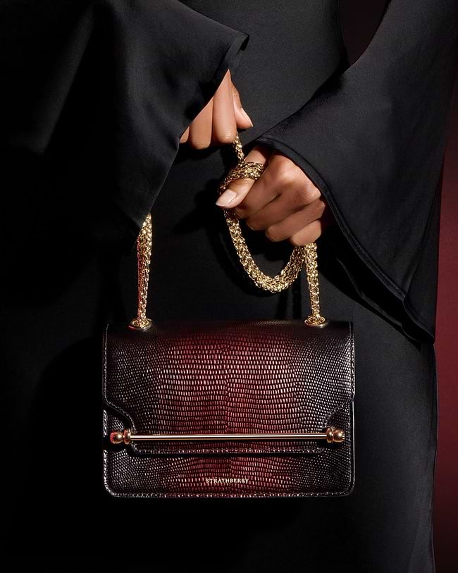 A woman's hand holding a brown purse