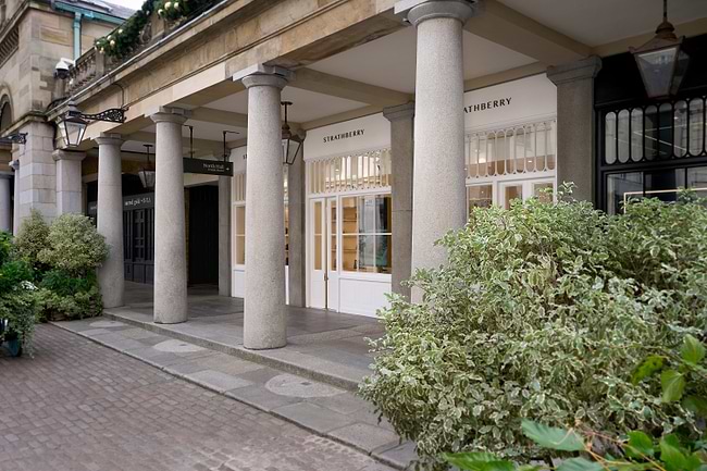 A building with columns and plants in front of it