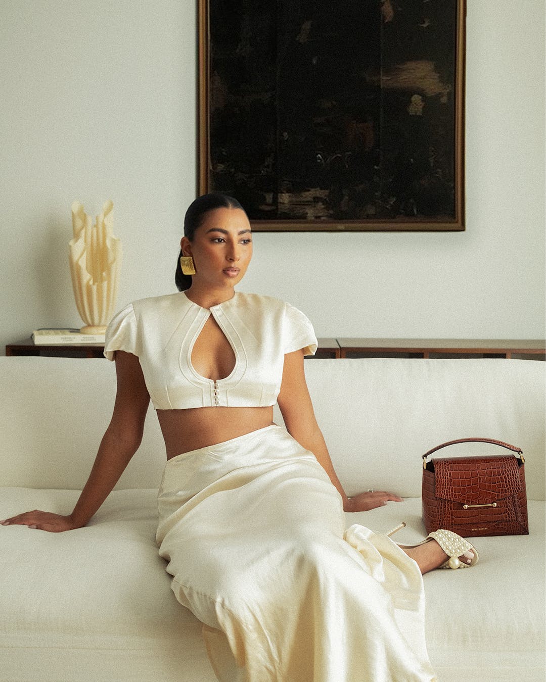 A woman is sitting on a white couch