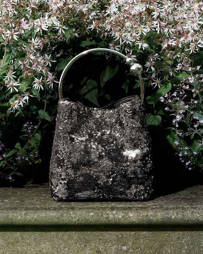 A black and white purse sitting on top of a cement slab