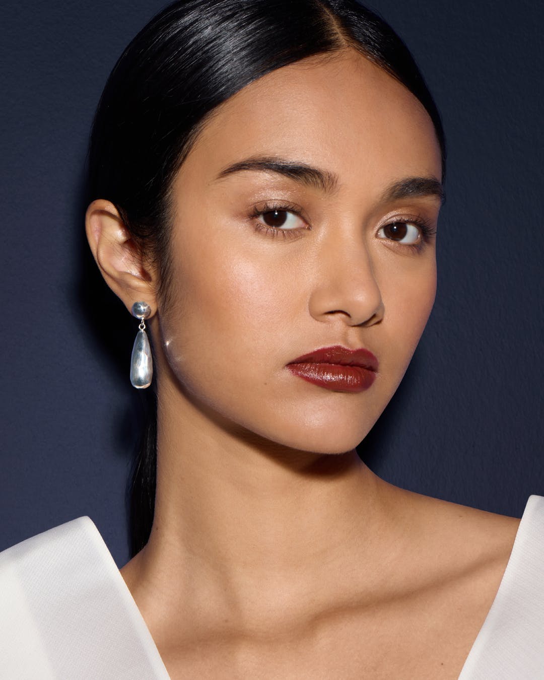 A close up of a woman wearing a white top