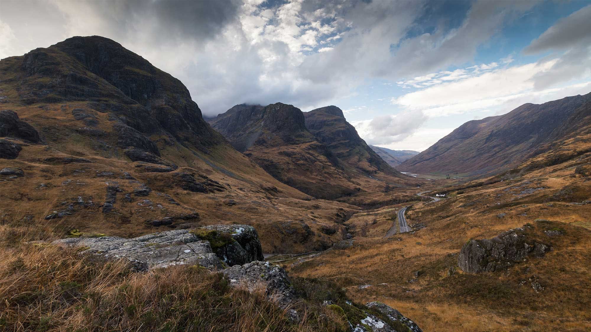 A scenic view of a valley with mountains in the background