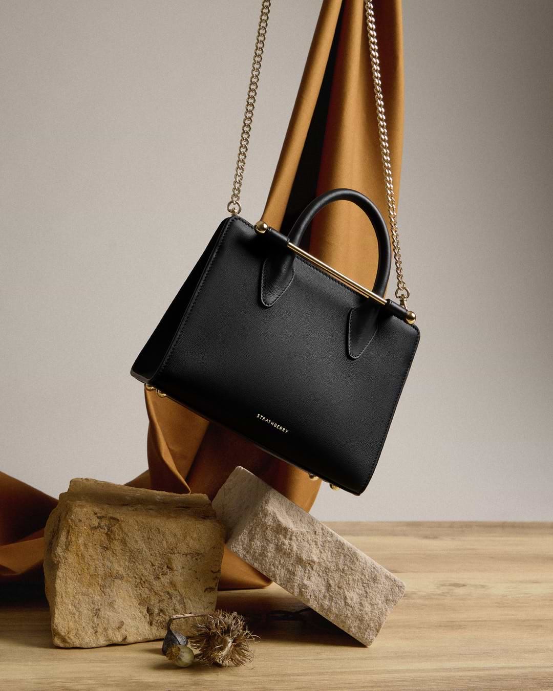A black purse sitting on top of a wooden table