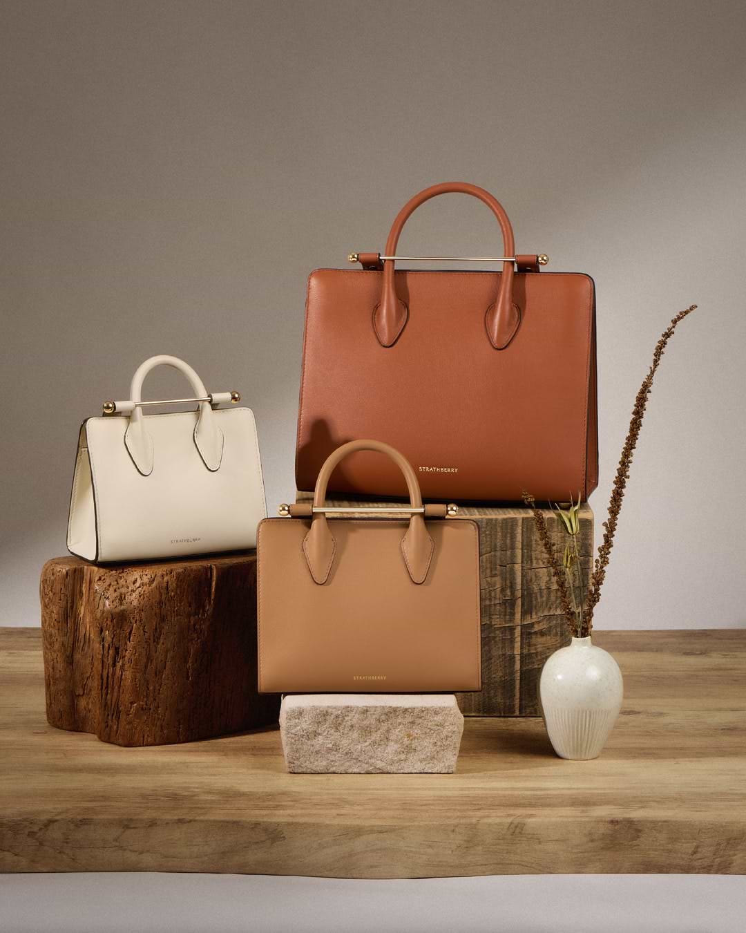 A group of purses sitting on top of a wooden table