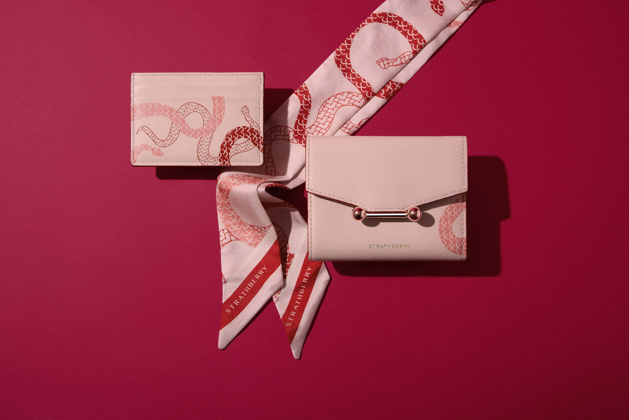 A white purse with a red and white scarf around it