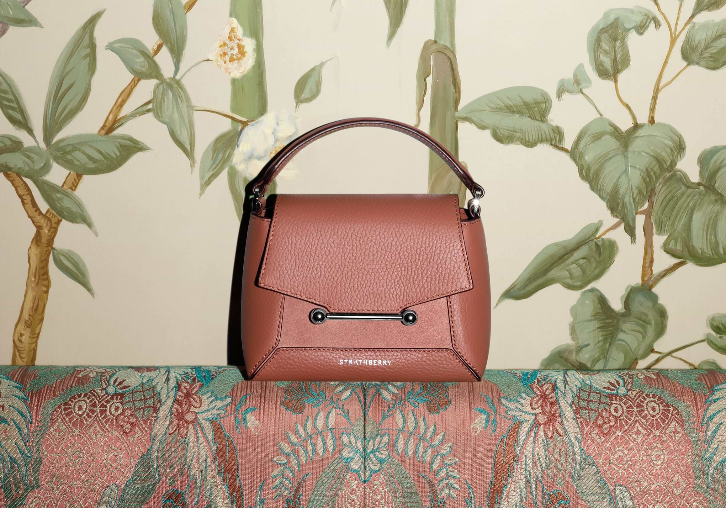 A brown purse sitting on top of a couch
