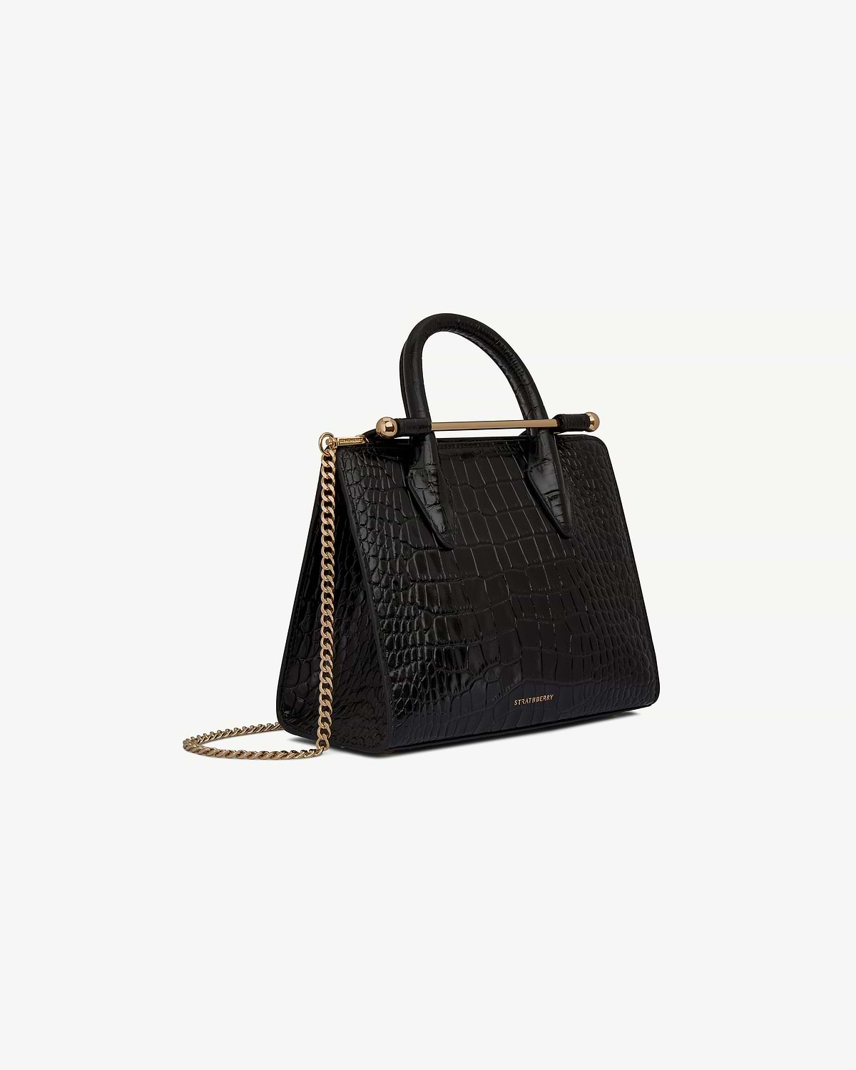 Strathberry mini tote in black croc with gold bar handle and chain strap.