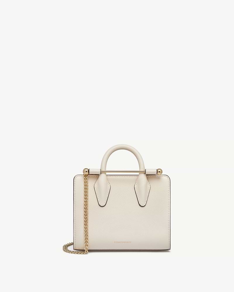 Strathberry vanilla nano tote with top handles, gold bar and chain strap.