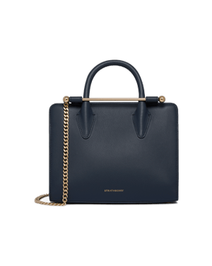 Strathberry marine blue mini tote with top handles and gold chain strap.